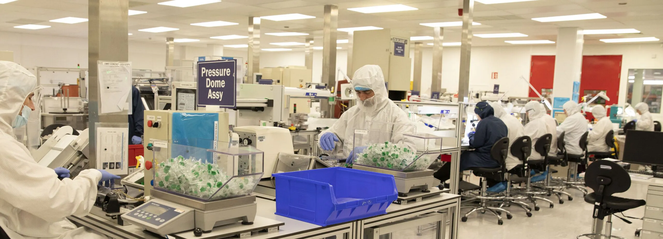 technicians seated and standing in sterile room
