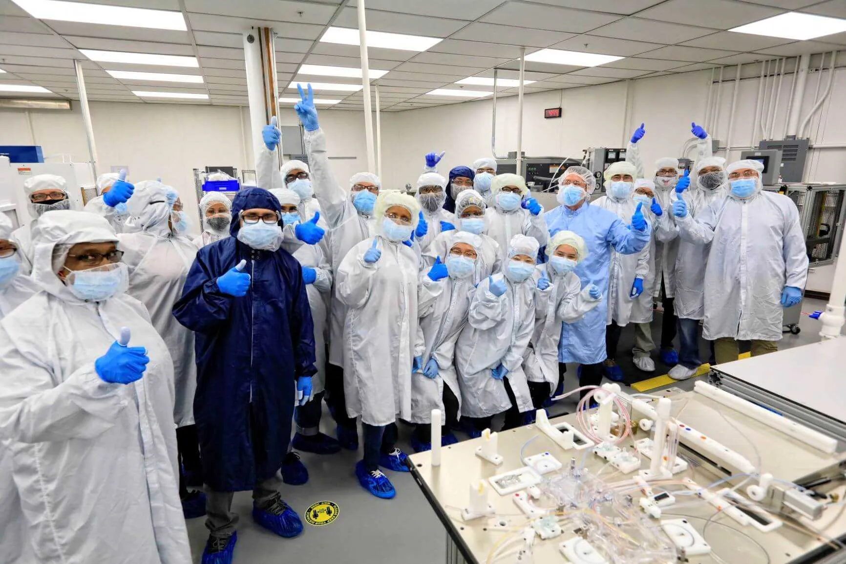 buffalo cleanroom manufacturing team smiling and giving thumbs up to camera